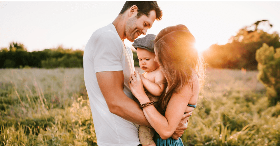 Family with baby in a field