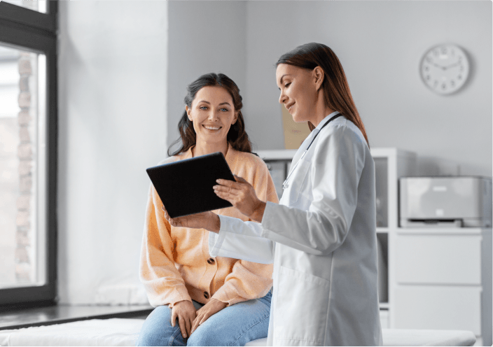 Pani doktor pokazująca kobiecie coś na tablecie